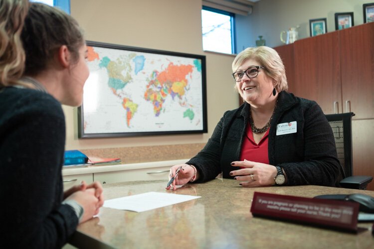 Nurse Barbra Mustert helps students understand the vaccinations required before international travel. 