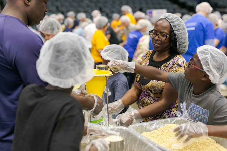 Volunteers with United Way prepare food at the VanAndel Arena during a huge volunteer event held every summer. 
