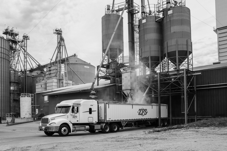 Trucks bring massive trailers full of soy to the processing facility.