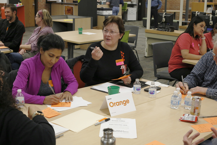 Community members write and share their opinions at a community meeting.