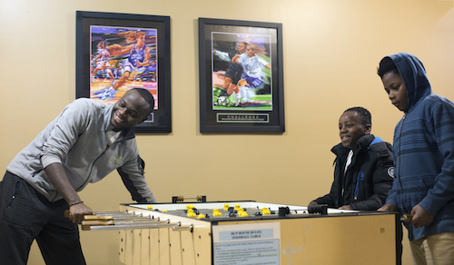 Havugimana plays in foosball with Jeremiah and Sinia Davidson--residents of Grandville Avenue. 