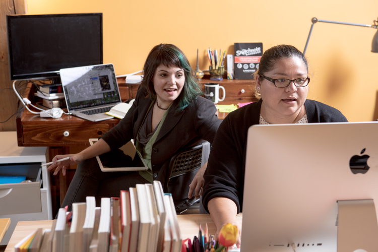 Alysha Lach White, left, speaks to Naomi Silas, right, about a shared project.