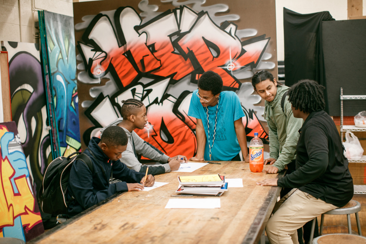 Students gather and share rhymes with each other. 