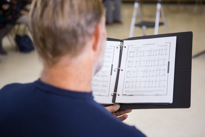 All choir members have sheet music to reference while singing.