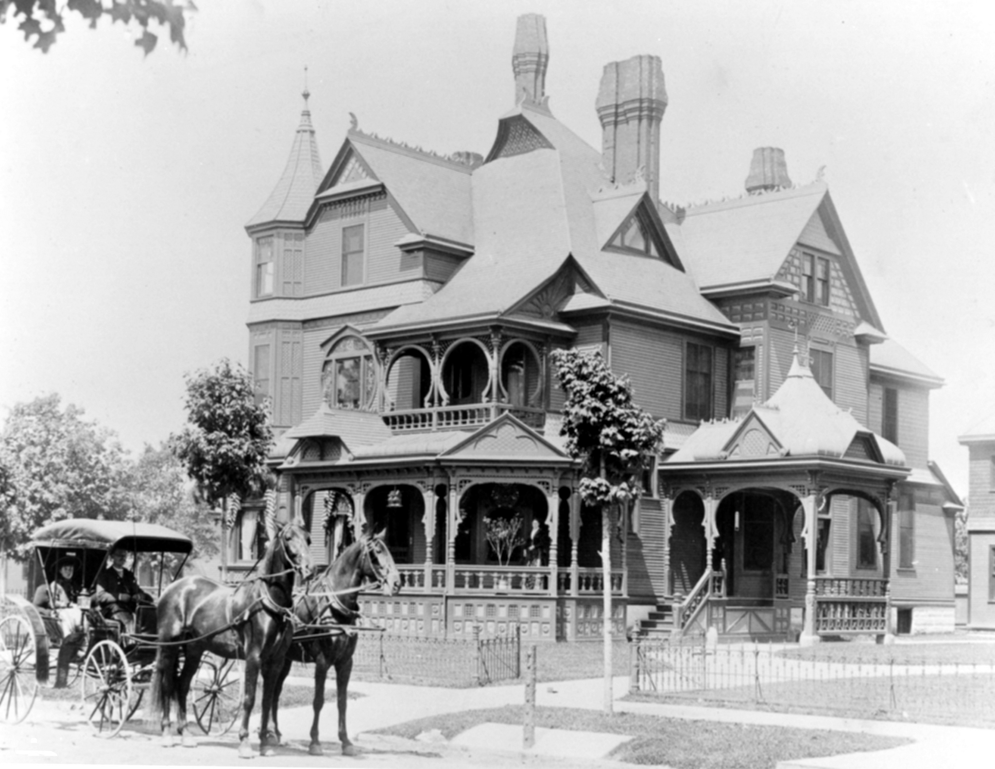 A photo of the Hackley House taken between 1890 and 1895, a time when the Hackley family was regularly purchasing flowers from Wasserman's to decorate their home. Here, Julia Hackley, Charles Hackley's wife, stands on the veranda. Taylor Bullis drives the two-horse carriage, and Erie Hackley Smith, the daughter of Charles and Julia Hackley, is the passenger. Photo courtesy of Hackley Public Library.