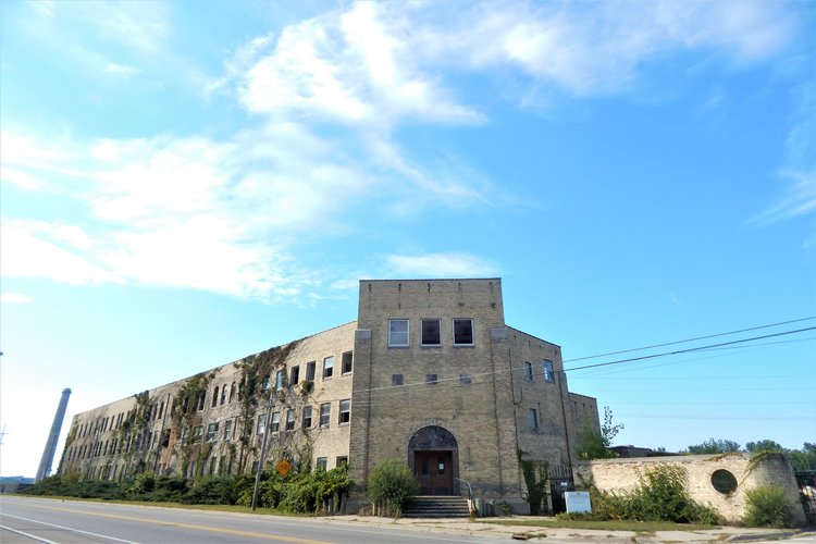 The Chase Hackley Piano Factory on the Sappi paper mill site and the smokestack behind it. The smokestack was torn down last Sunday, and the factory is in the process of being demolished. Photo by Anna Gustafson