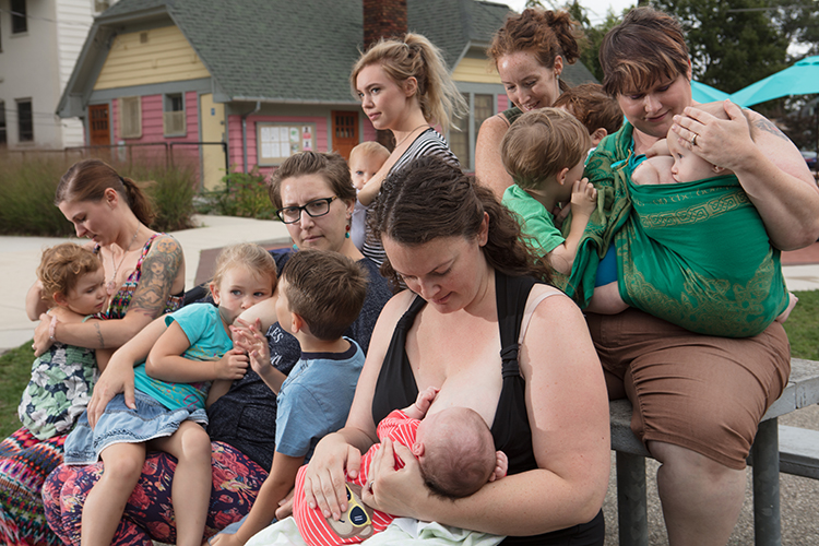 Toshia Gustafson feeds her son, Ezra, with the support of her breastfeeding group at Cherry Street Park.