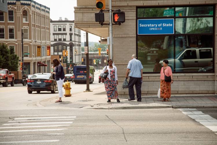 People wait to cross the street downtown at the intersection of Division and Fulton. 