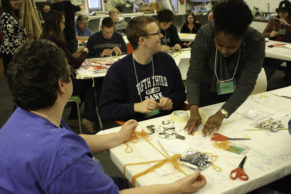 Volunteers help individuals with disabilities create art during Artists Creating Together's Adult Art Class.