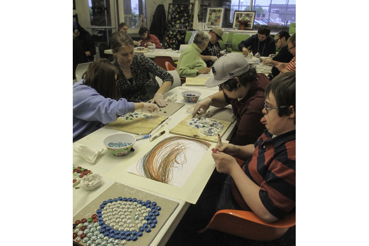 Volunteers help individuals with disabilities create art during Artists Creating Together's Young Adult Art Class.