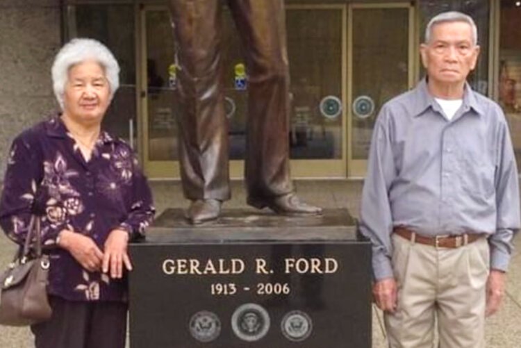 Amberly Nguyen's grandparents pose in front of the statue of President Gerald R. Ford.