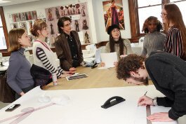 KCAD's Fashion Studies students gather around the table to discuss runway show plans.
