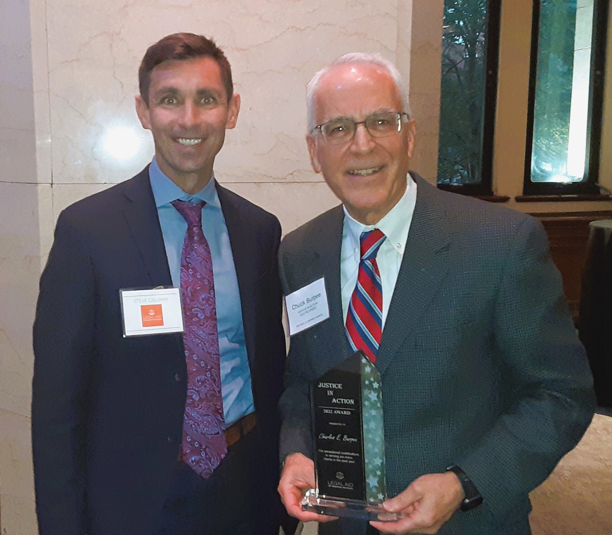 Charles (Chuck) Burpee, right, received the 2022 Justice In Action Award, which recognized his extraordinary expungement advocacy, and poses with Steve Grumm, director of community engagement for Legal Aid of Western Michigan.