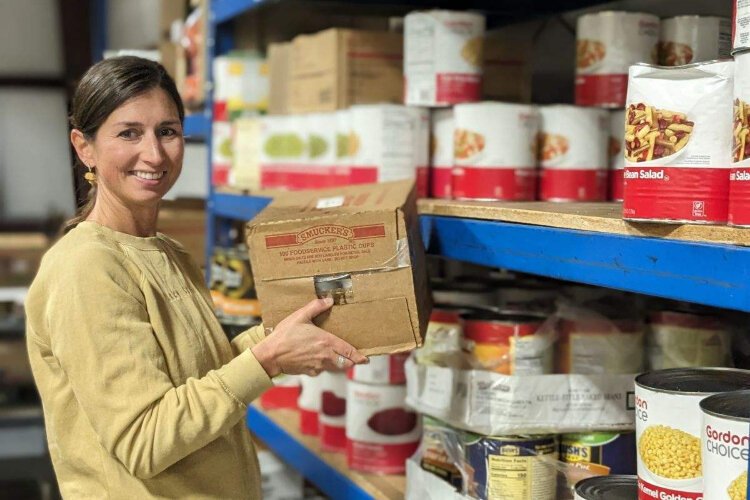 A United Way volunteer stocks food pantry shelves in Allegan County.