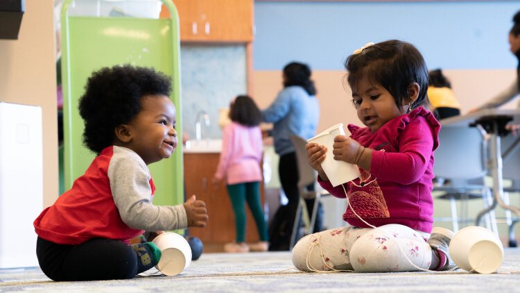 Children are never too young to enjoy practicing communication skills on a paper cup and string telephone. 
