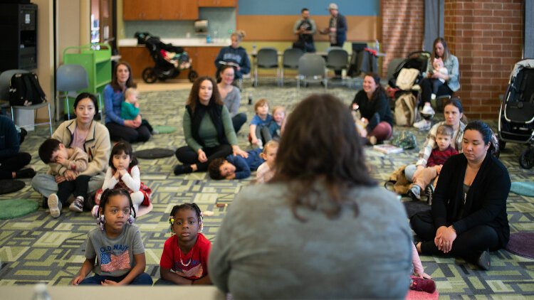 Young clildren attend storytime at a KDL branch library with their grownups.