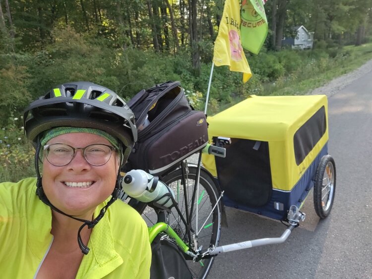 Avid cyclist Betsy Cech on her recumbent triker with her dog, Clara, in tow.