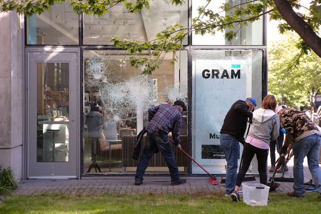 Volunteers clean up at the Grand Rapids Art Museum. The double-pane safety glass prevented rioters from entering the museum, and no art was  damaged, according to a statement from the GRAM.