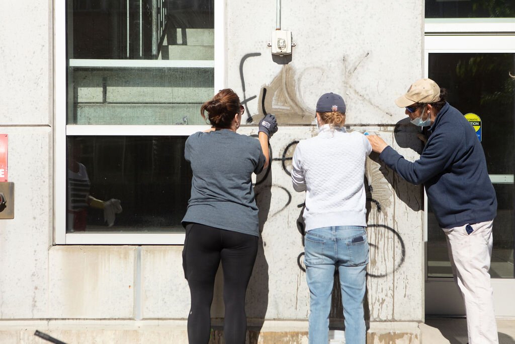 Volunteers clean grafitti.