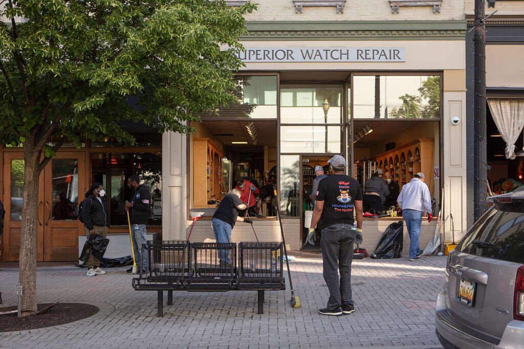 Volunteers work to replace windows for Superior Watch Repair on Monroe Center.