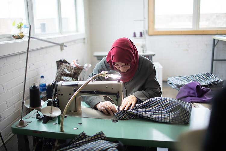 Mariam Al-Swiadi works on sewing a bag.